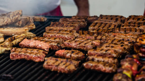 soczyste parowanie mięsa na grillu węglowym, steki wieprzowe, pierś z kurczaka, kiełbaski, kawałki kotletów mięsnych, rumuńskie mięso mielone (mici) na festiwalu street food - tirgoviste zdjęcia i obrazy z banku zdjęć