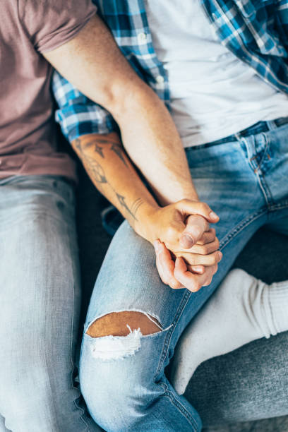 Unrecognizable gay couple holding hands