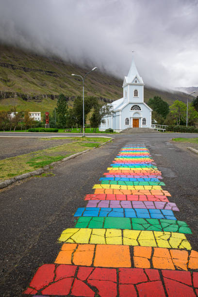 Rainbow path and church, Seydisfjordur, Eastern Iceland A rainbow painted street place of worship stock pictures, royalty-free photos & images