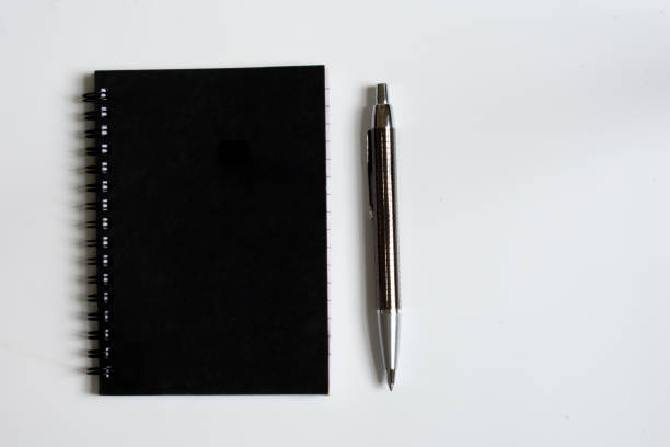 istock Black notes and pen isolated on white background top view with copy space 1174204973
