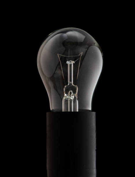 istock Incandescent lamp on a black background, the spiral breaks and the lamp itself 1174207021