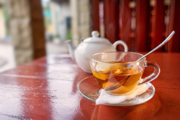 Tea with lemon in a transparent mug on the red table