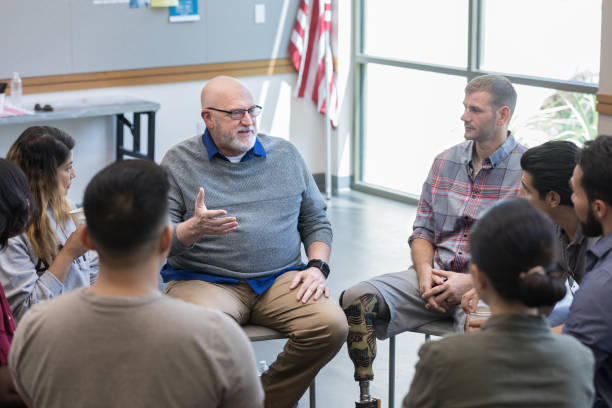 istock Therapist speaks and gestures as support group listens 1174210593