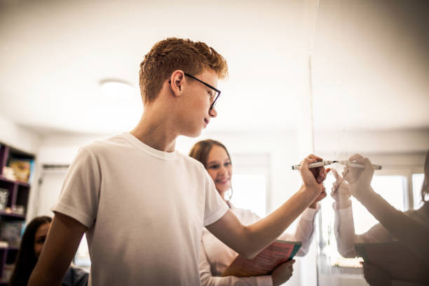 istock Happy mature teacher assisting school kids 1174210656