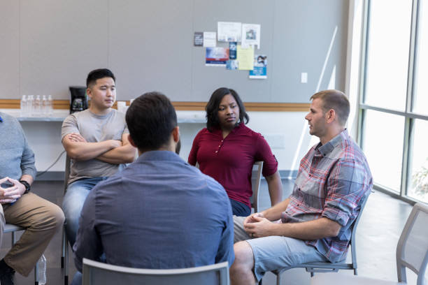 istock Mid adult man shares during weekly group therapy 1174211170
