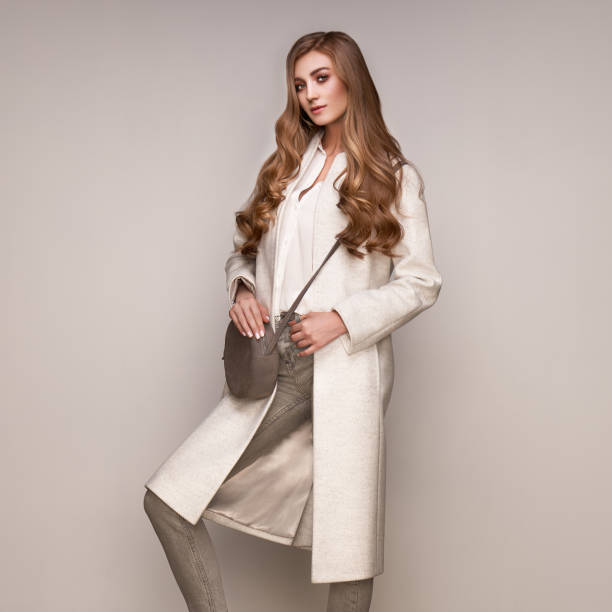istock Young woman in white autumn coat 1174211220