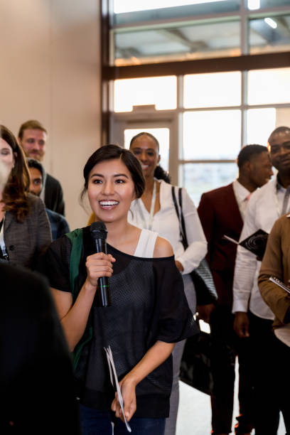 istock Excited woman asks a question during business conference 1174211860