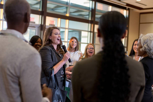 istock Cheerful woman ask question during town hall meeting 1174211885