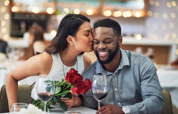 You deserve all the smooches in the world Cropped shot of an affectionate  young woman kissing her boyfriend on his face in a restaurant valentines day holiday photos stock pictures, royalty-free photos & images