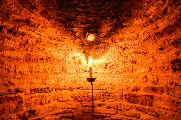istock Burning candle in a dark cellar niche, which was built with bricks 1174219706