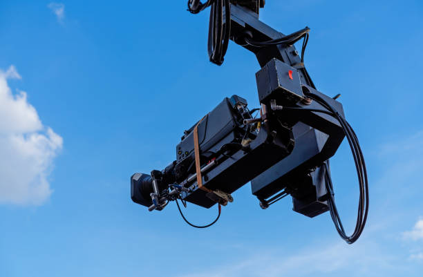 istock TV camera on the operator crane. Camcorder on a background of blue sky. 1174222248