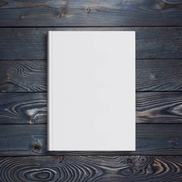 white hard cover book on dark wood - paper sheet imagens e fotografias de stock