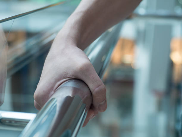 uomo che tiene un corrimano nel primo piano del centro commerciale - stair rail foto e immagini stock