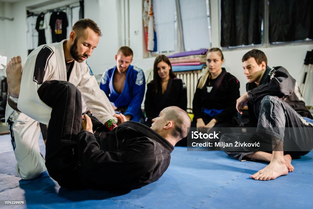 Brazilian Jiu jitsu bjj black belt teaching class or private lessons to his students at the academy martial arts ground fight Martial Arts Stock Photo