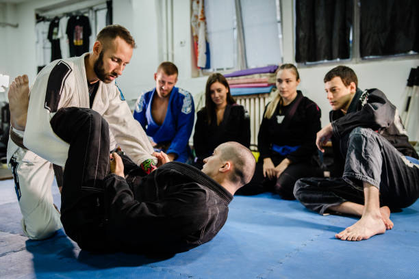 Brazilian Jiu jitsu bjj black belt teaching class or private lessons to his students at the academy martial arts ground fight stock photo