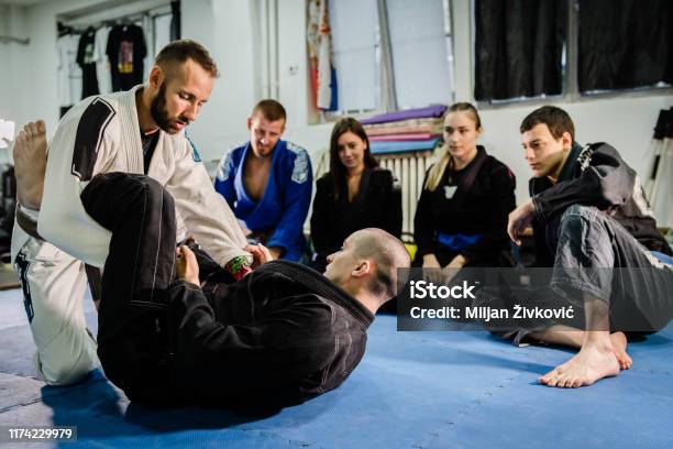 Brazilian Jiu Jitsu Bjj Black Belt Teaching Class Or Private Lessons To His Students At The Academy Martial Arts Ground Fight Stock Photo - Download Image Now