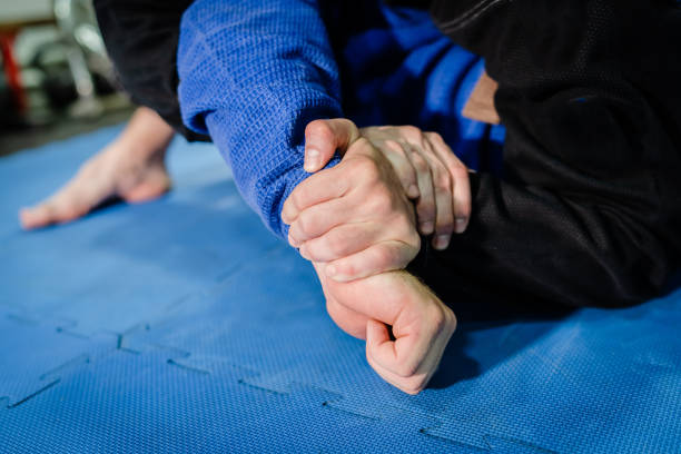 istock Brazilian Jiu jitsu BJJ jiujitsu training sparring athlete fighter applying kimura or americana shoulder lock submission on his opponent during technique practice 1174231771
