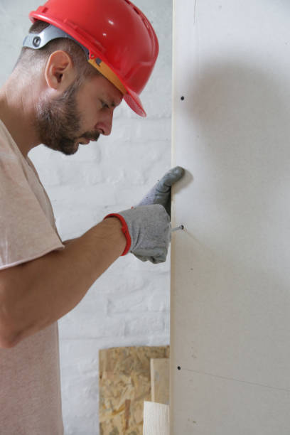 istock Man drilling screws into plasterboard with a screwdriver, home improvement concept 1174234556