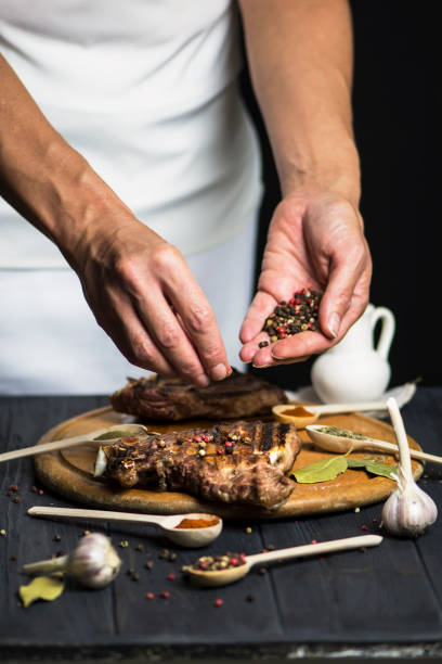 istock hand cooks appetizing barbecue pork meat on the bone with spices 1174236358