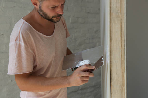 istock Man plastering wall with putty-knife. Fixing wall surface and preparation for painting. DIY housing improvement project. 1174237248