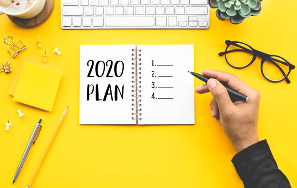 istock 2020 pla2020 plan concepts with youngman writing checklist on notepad on color desk table. 1174237297