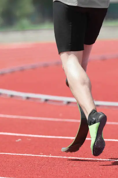 athlete with prosthesis on the leg in the running track of sport venue