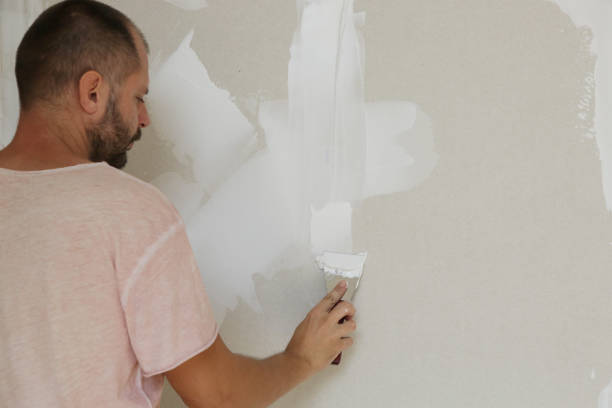 istock Man plastering wall with putty-knife. Fixing wall surface and preparation for painting. DIY housing improvement project. 1174238400