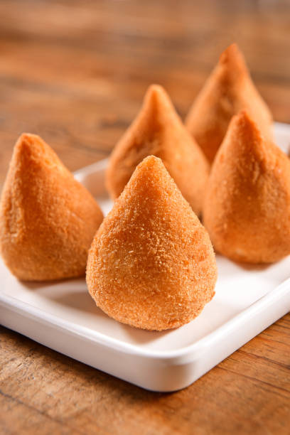 Brazilian Snack-Coxinha Coxinhas plate on wooden background coxinha stock pictures, royalty-free photos & images