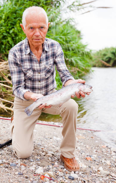 istock Mature fisherman examining catch 1174241258