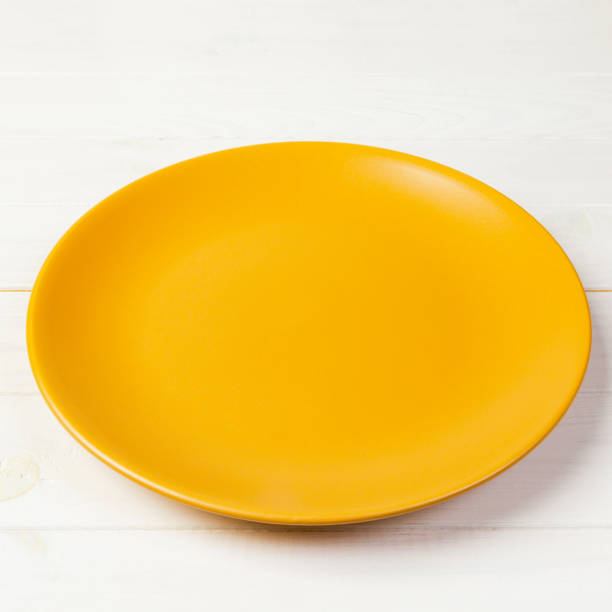 istock Yellow Round Plate on wooden table background. Top view, template for your design 1174241263