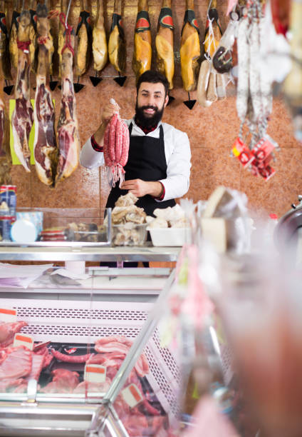 istock Man seller showing different sausages 1174242936