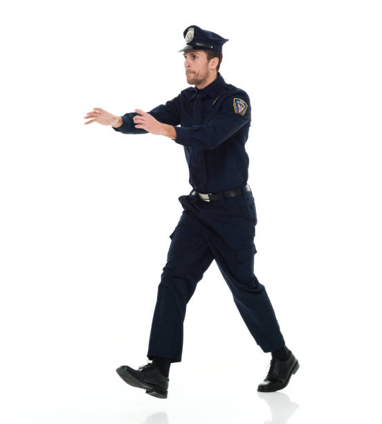 One man only / full length / side view / profile view of 30-39 years old adult handsome people caucasian male / young men police force / security staff wearing uniform / necktie / hat / badge and showing reaching / crime un hombre sólo / longitud completa / vista lateral / vista de perfil de 30-39 años de edad adulto gente guapo personas caucásicas hombres / hombres jóvenes policía fuerza / personal de seguridad que lleva uniforme / corbata / sombrero / insignia y mos