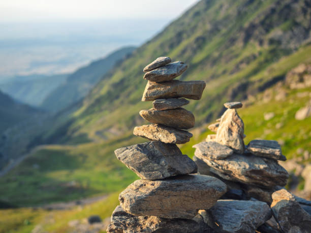 일몰 따뜻한 빛에 흐린 산 배경에 균형 잡힌 돌 스택 - cairn stacking stone rock 뉴스 사진 이미지