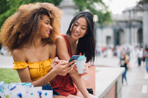 istock Girls sitting on a bench and laughing 1174249632