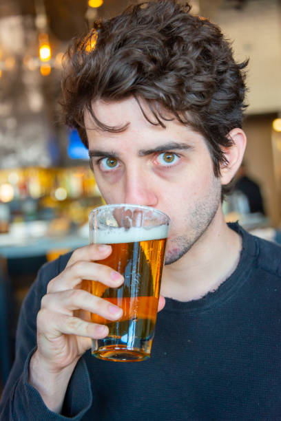 istock Young millennial looking at the camera drinking beer 1174252548