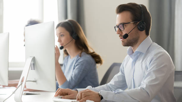 istock Male employee in headset with microphone work on pc 1174254761