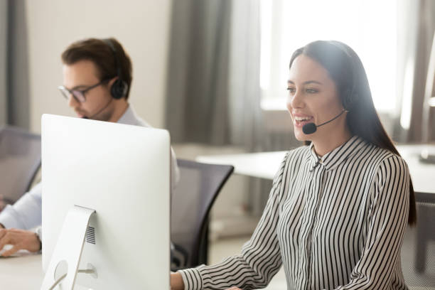 istock Smiling female call center agent talk consulting client online 1174254803