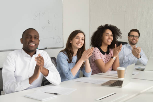 istock Smiling diverse employees applaud thanking speaker for presentation 1174254832