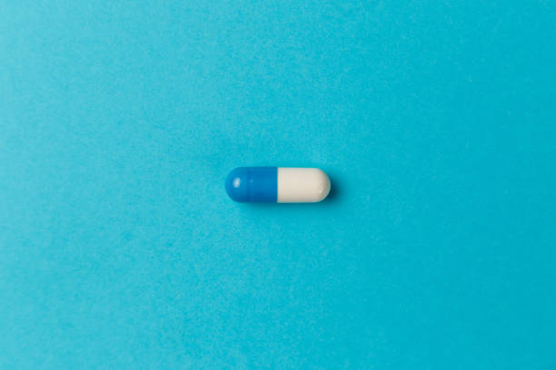 istock Pharmaceutical medicine pills, tablets and capsules on blue background. Top view. Flat lay. Copy space. Medicine concepts. Minimalistic abstract concept 1174254934