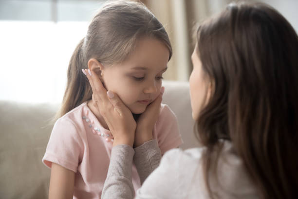 istock Loving young mother touching upset little daughter face, supporting 1174255046