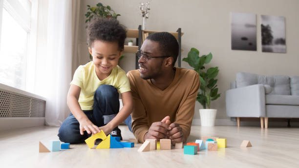 istock Black dad and little son play with colorful blocks 1174255196