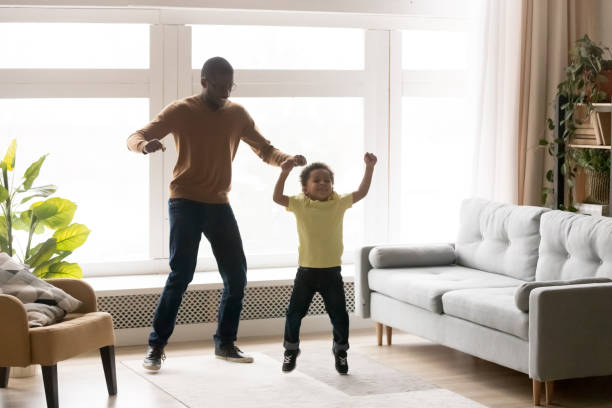 istock Happy black dad and son have fun jumping together 1174255198