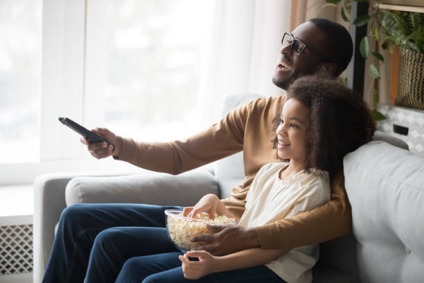 istock Happy black dad and daughter cuddle watching TV 1174255246
