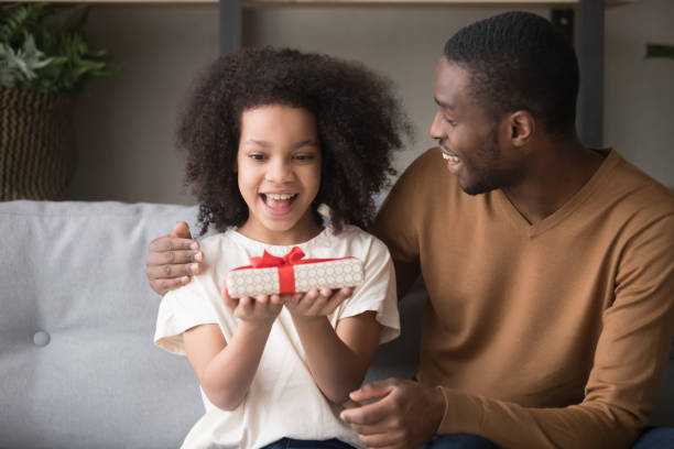 istock Loving black dad present gift box to happy daughter 1174255287