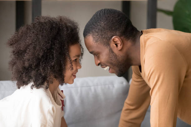 istock Black father and daughter have fun playing peeper game 1174255415