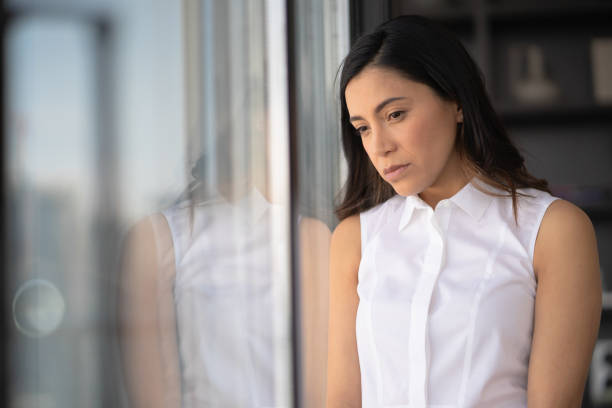 istock Sad Latina woman leaning on window 1174259812