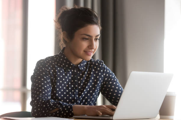 istock Attractive indian woman office worker typing on computer 1174262764