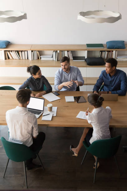 istock Vertical above view diverse business people negotiating in boardroom 1174262798