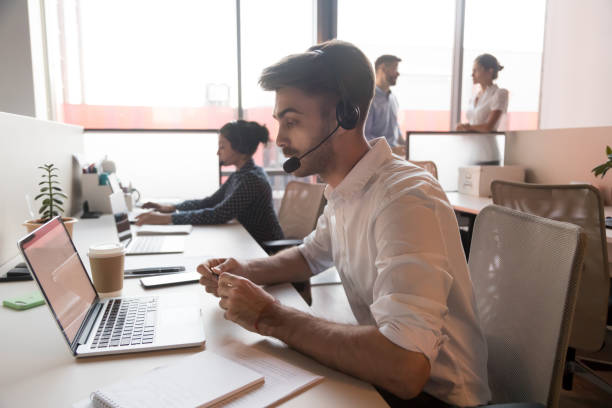 istock Call center agent wearing headset consulting client online 1174262835