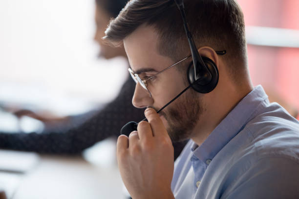 closeup call center worker chatting with client using microphone - center occupation headset on the phone imagens e fotografias de stock